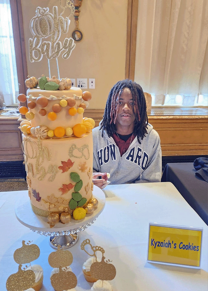 Artisan baker dusting powdered sugar over fresh pastries at the Syracuse Bakers Expo